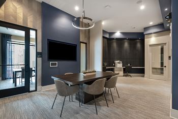 A modern dining room with a large table and chairs.